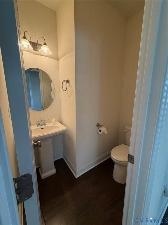 12146 Elnora Lane, Glen Allen, VA 23059 Pedestal sink with chrome faucet, circular wall mirror, and wood-finish flooring