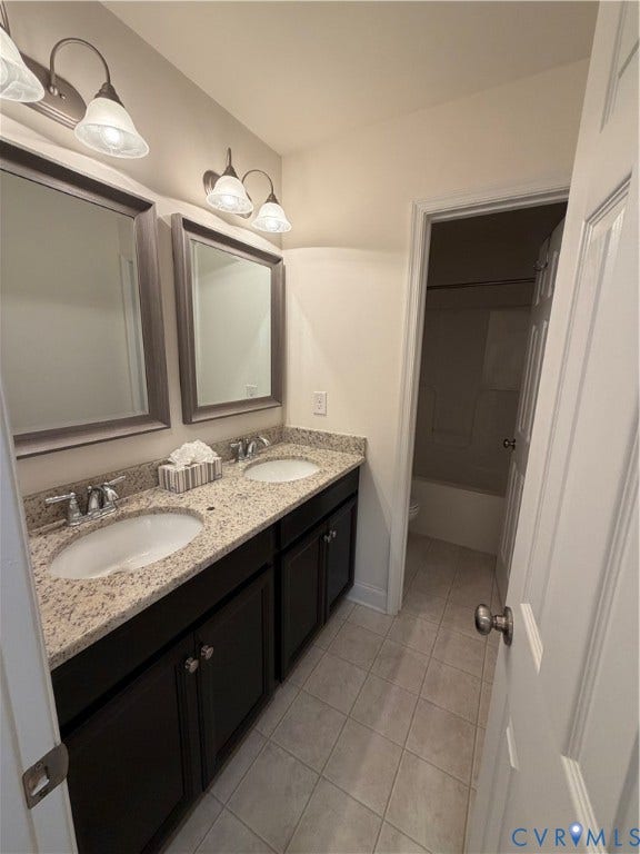 12146 Elnora Lane, Glen Allen, VA 23059 Dual vanity with undermount sinks, granite-finish countertop, dark wood-finish cabinetry, and tiled flooring