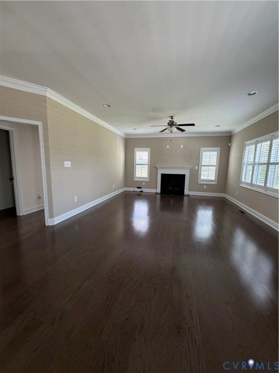 12146 Elnora Lane, Glen Allen, VA 23059 Spacious living area featuring dark wood-finish flooring, a white mantel fireplace, and multiple windows with plantation shutters