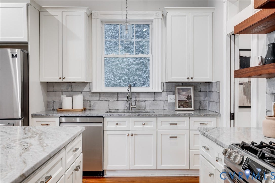 1416 Oakwood Avenue, Church Hill, Richmond, VA 23223 White shaker-style cabinetry, stainless steel appliances, light-toned stone countertops, and a gray brick-patterned backsplash