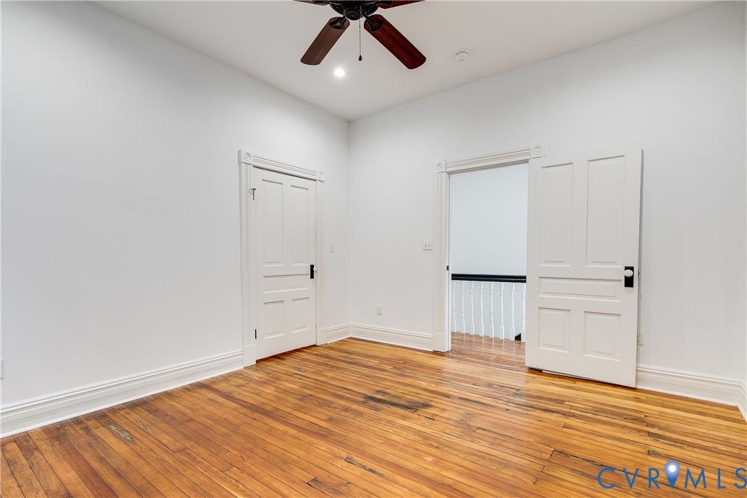 1416 Oakwood Avenue, Church Hill, Richmond, VA 23223 Hardwood flooring throughout, bright white walls, traditional paneled doors, intricate baseboard molding, and a ceiling fan with integrated lighting