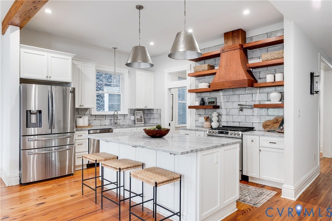1416 Oakwood Avenue, Church Hill, Richmond, VA 23223 Gourmet kitchen featuring a central island with a stone countertop, white shaker cabinetry, stainless steel appliances, a wood range hood, and open shelving on a brick-patterned backsplash