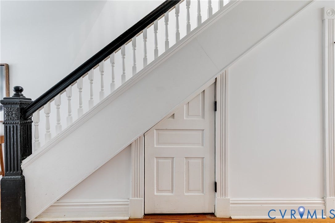 1416 Oakwood Avenue, Church Hill, Richmond, VA 23223 Staircase with black newel post, black handrail, white balusters, and integrated panel door