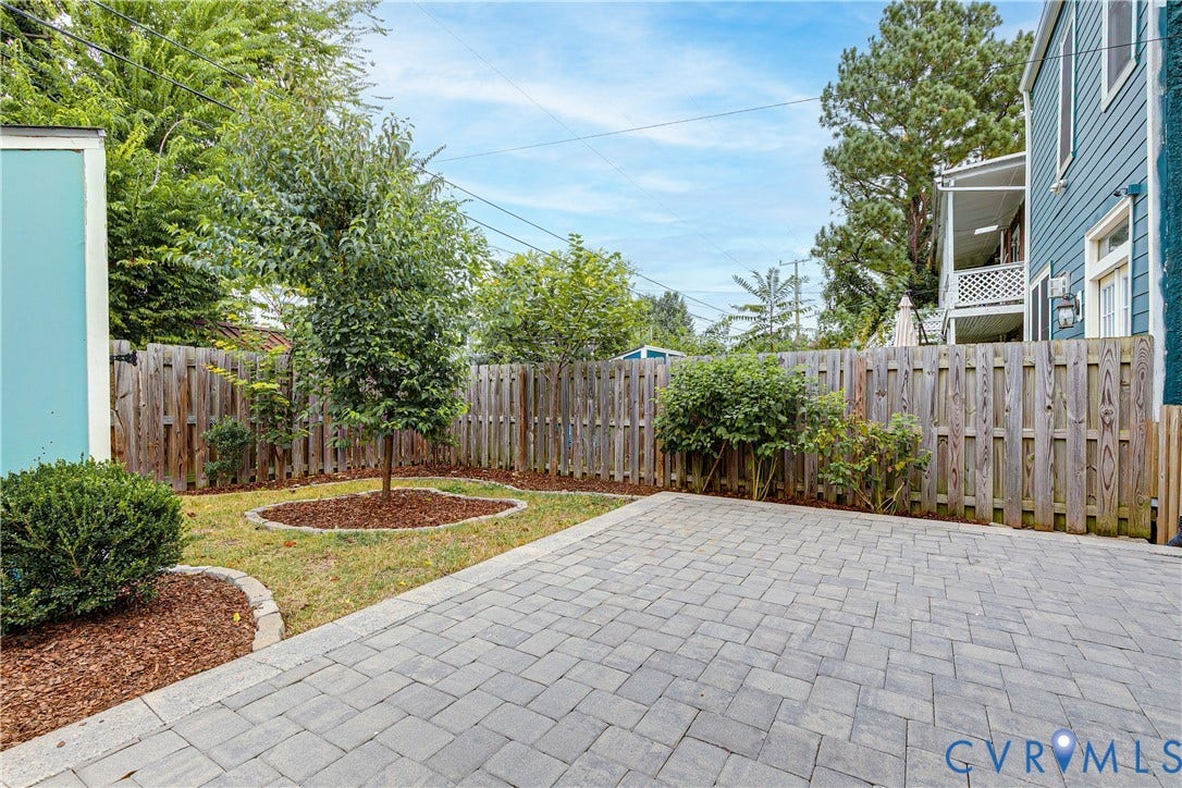 1416 Oakwood Avenue, Church Hill, Richmond, VA 23223 Paver patio with a wood privacy fence, featuring a landscaped grass area and mature greenery
