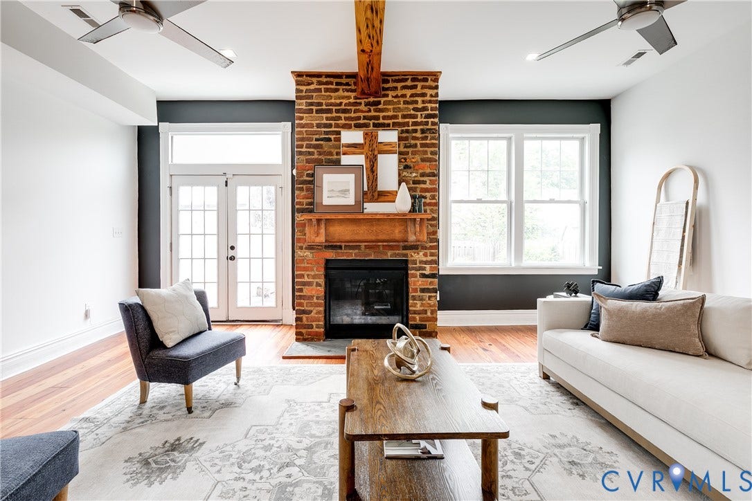 1416 Oakwood Avenue, Church Hill, Richmond, VA 23223 Exposed brick fireplace with a wood mantel, wood-finish flooring, white double-pane windows, and white French doors with transom