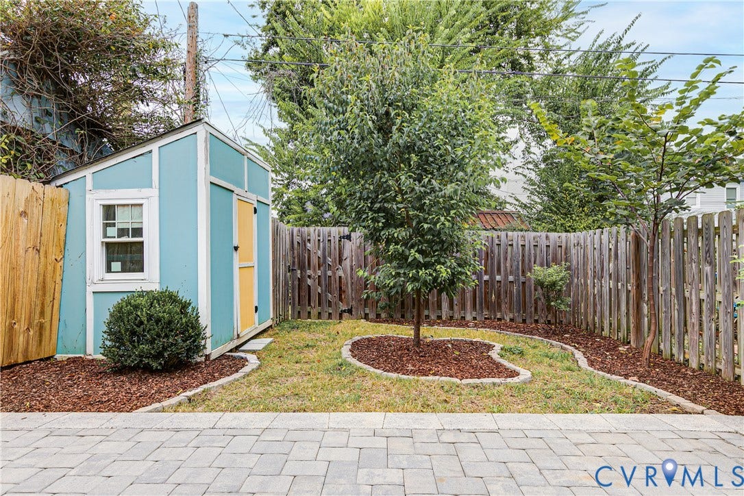 1416 Oakwood Avenue, Church Hill, Richmond, VA 23223 Paver patio leading to a fenced yard with a storage shed and planted garden beds