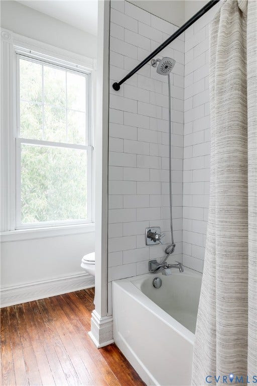 1416 Oakwood Avenue, Church Hill, Richmond, VA 23223 White subway tile shower surround, chrome shower fixtures, white bathtub, wood-finish flooring, and a double-hung window