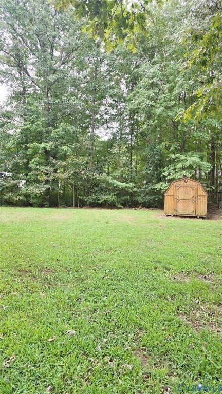 3807 Mooring Way, Chester, VA 23831 Expansive green lawn with a wood-sided storage shed and mature trees