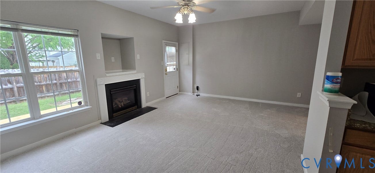 5506 Millwheel Lane, Henrico, VA 23228 Living area featuring a fireplace with a mantel, built-in shelving, vaulted ceiling, and a ceiling fan with light fixture