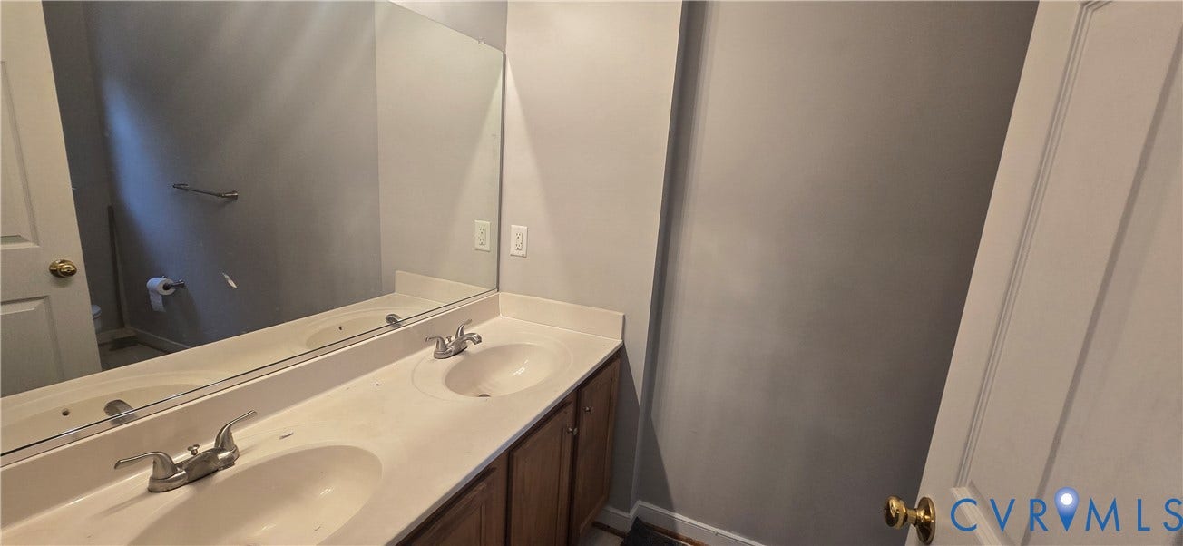 5506 Millwheel Lane, Henrico, VA 23228 Double vanity with integrated sinks, brushed nickel faucets, and wood-finish cabinetry