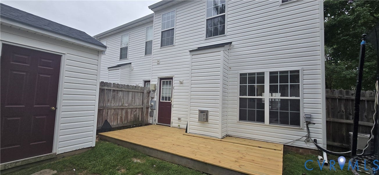 5506 Millwheel Lane, Henrico, VA 23228 Exterior featuring a wood privacy fence, a newly constructed wood deck, and a detached storage shed with a dark-paneled door