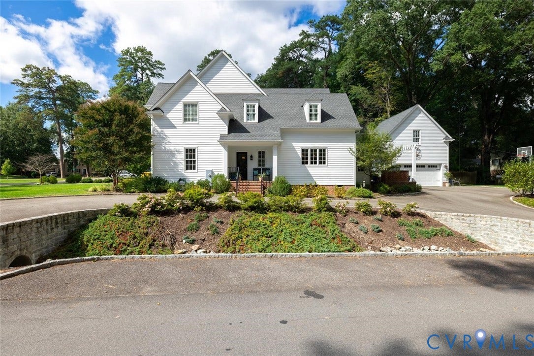 Side of home with curved driveway and side entry