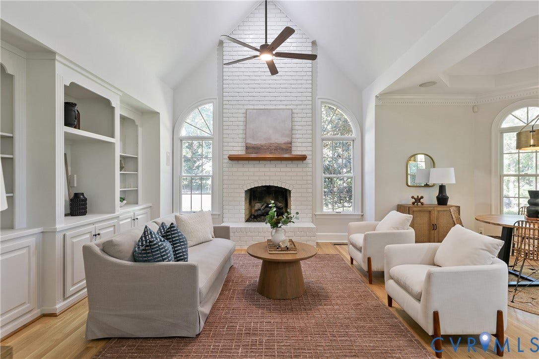 2621 Glenalmond Court, Powhatan, VA 23139 Vaulted ceiling with exposed beam, white painted brick fireplace, built-in shelving, hardwood flooring, and arched windows