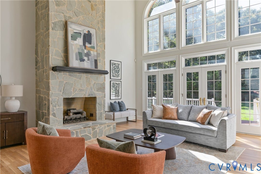 2621 Glenalmond Court, Powhatan, VA 23139 Vaulted ceiling with an arched transom window, floor-to-ceiling windows, stone-clad fireplace with a mantel, and wood-finish flooring