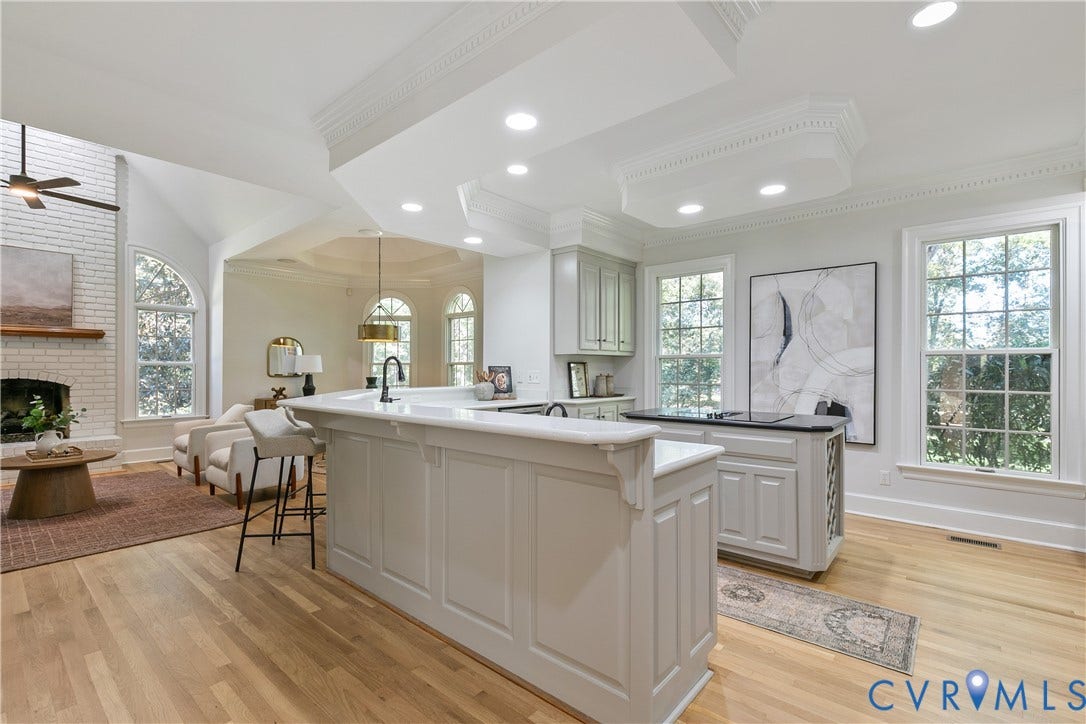 2621 Glenalmond Court, Powhatan, VA 23139 Kitchen and living area featuring a breakfast bar, recessed lighting, wood-finish flooring, white brick fireplace, and vaulted ceiling
