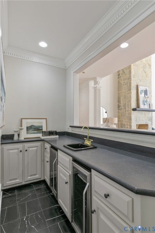 2621 Glenalmond Court, Powhatan, VA 23139 Wet bar featuring a dark countertop, white cabinetry with dark hardware, undermount sink with a brass-finish faucet, and integrated beverage refrigerators