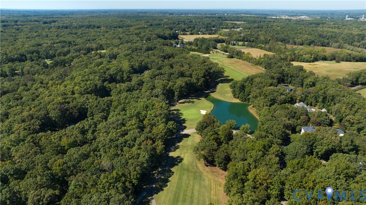 2621 Glenalmond Court, Powhatan, VA 23139 Expansive golf course property featuring a manicured green, a water feature, and surrounding mature trees