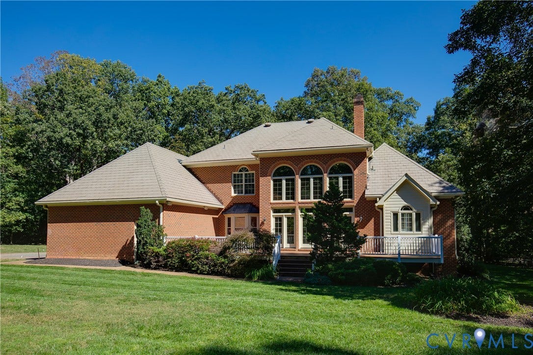 2621 Glenalmond Court, Powhatan, VA 23139 Brick exterior with a multi-level roofline, featuring a dedicated deck area, arched windows, and a prominent chimney