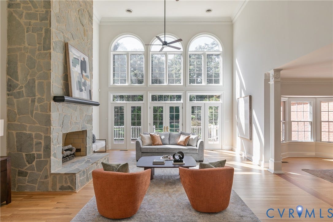 2621 Glenalmond Court, Powhatan, VA 23139 Two-story stone fireplace with hearth, arched transom windows, French doors, hardwood flooring, and decorative column accents