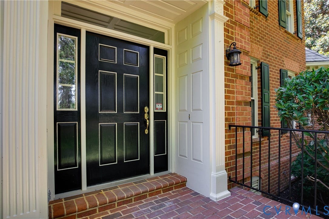 2621 Glenalmond Court, Powhatan, VA 23139 Brick exterior with a paneled black entry door, sidelight windows, and a brick paver landing