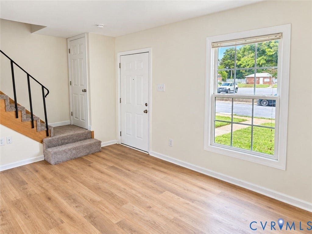 4609 Coldstream Drive, Richmond, VA 23234 Wood-finish flooring throughout, bright window with gridded panes, painted walls, and a carpeted staircase with a metal handrail