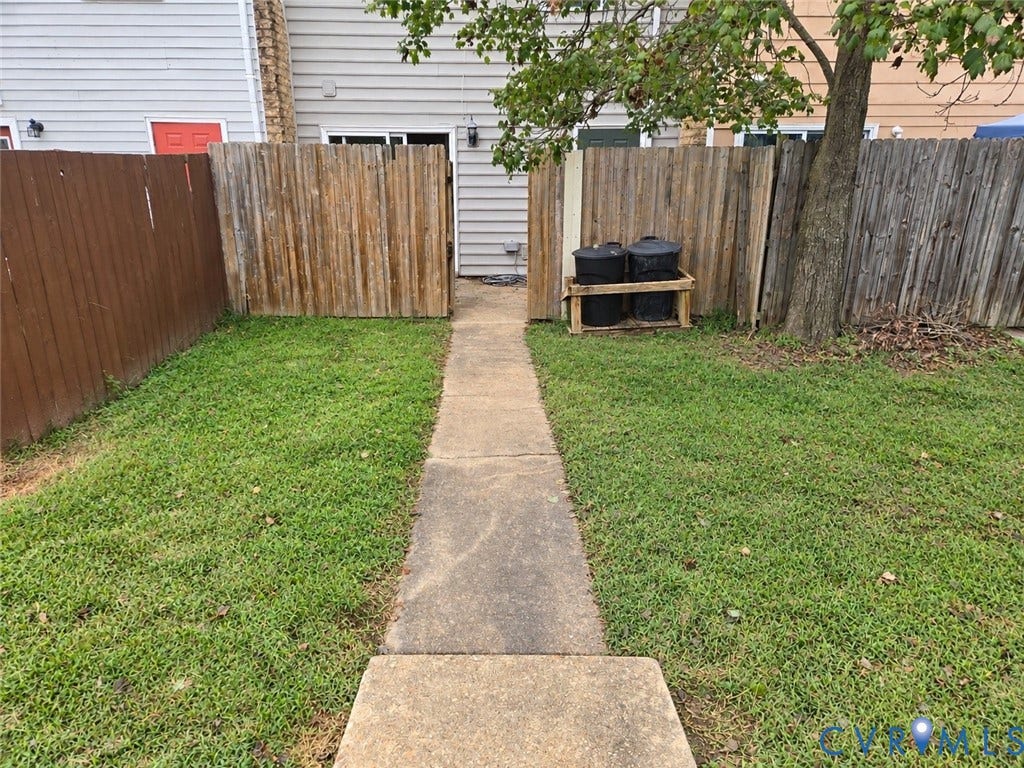 4609 Coldstream Drive, Richmond, VA 23234 Manicured lawn with a concrete pathway and wood fencing