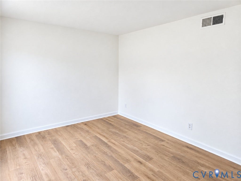 4609 Coldstream Drive, Richmond, VA 23234 Wood-finish flooring with white trim, white walls, and a white ceiling with an integrated air vent