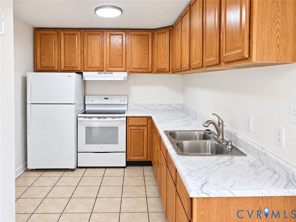 4609 Coldstream Drive, Richmond, VA 23234 Wood-finish cabinetry complemented by white countertops and a double basin stainless steel sink