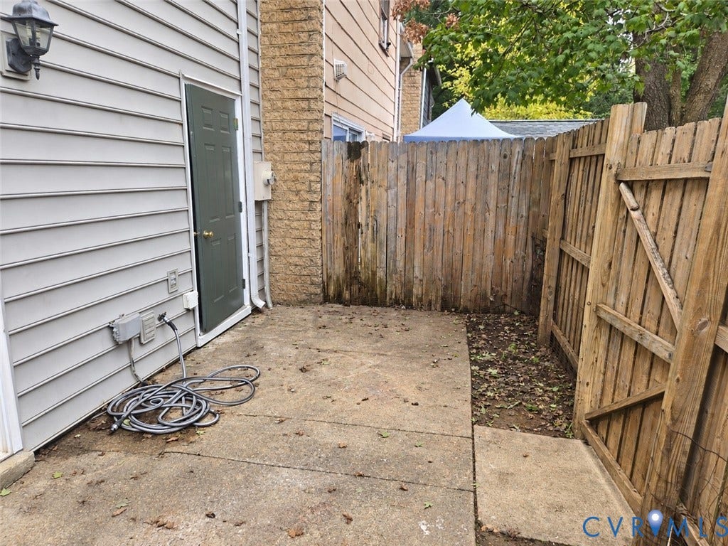 4609 Coldstream Drive, Richmond, VA 23234 Concrete patio with a wood privacy fence and exterior door