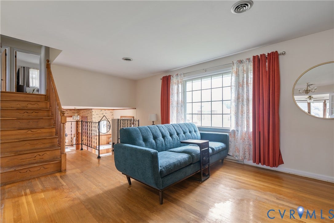 Bright formal living room looking back towards stairs to bedrooms