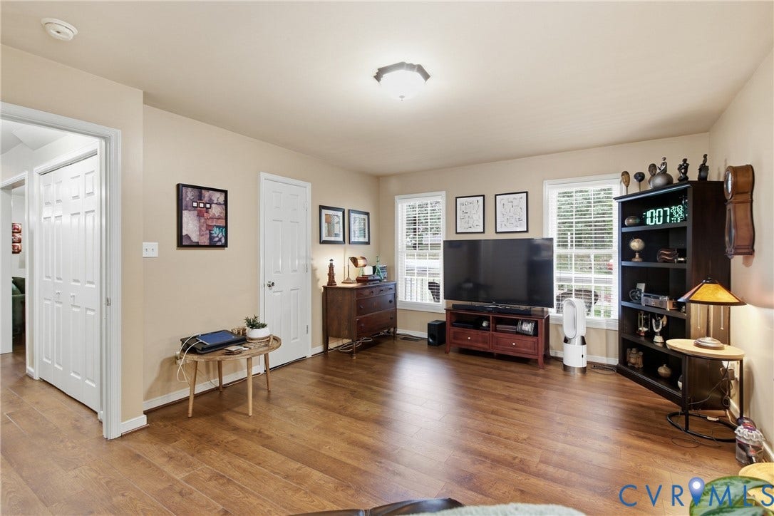 10624 Hamlin Drive, Hamlin Estates, Chester, VA 23831 Spacious room featuring wood-finish flooring, light neutral wall paint, white trim, and two white-framed windows with blinds