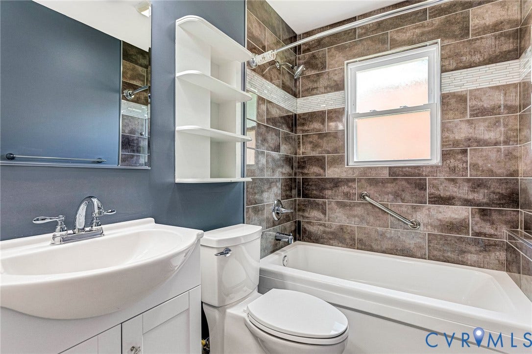 507 Walnut Avenue, Walnut Court, Colonial Heights, VA 23834 Bathroom featuring a white vanity with integrated sink, chrome faucet, wall-mounted shelving, tiled shower surround with accent band, and a white bathtub