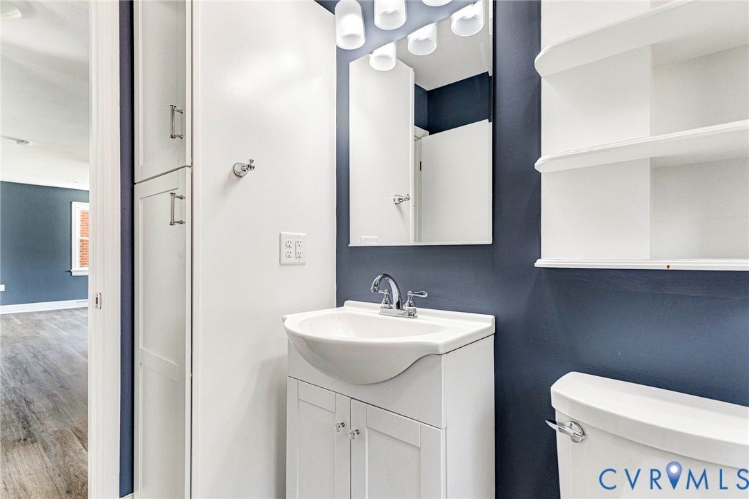 507 Walnut Avenue, Walnut Court, Colonial Heights, VA 23834 Vanity with integrated sink and chrome faucet, wall-mounted mirror, overhead lighting fixture, and built-in shelving