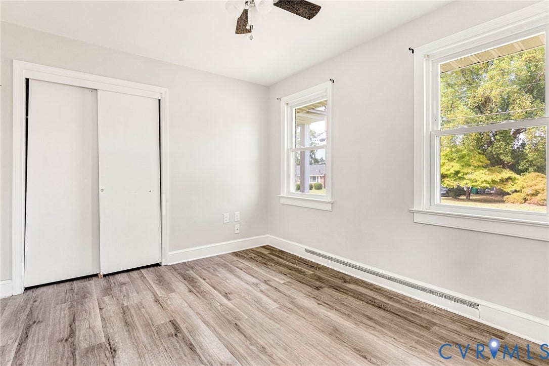 507 Walnut Avenue, Walnut Court, Colonial Heights, VA 23834 Light gray wall paint, wood-finish flooring, two large windows with white trim, and a ceiling fan