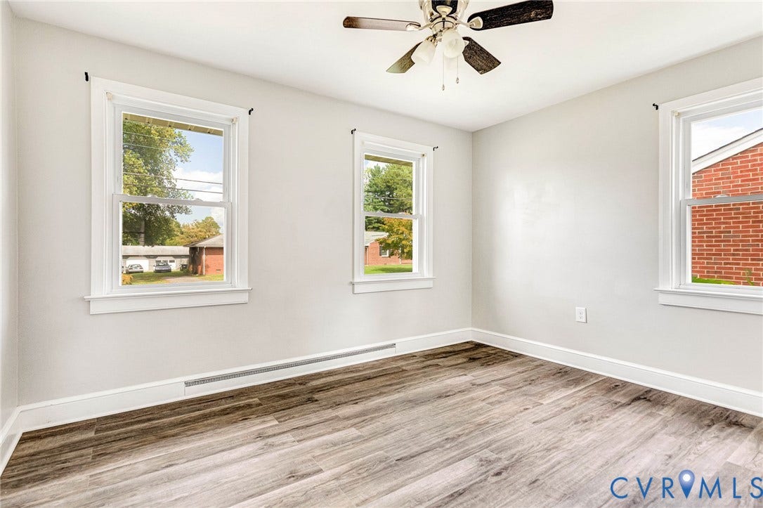 507 Walnut Avenue, Walnut Court, Colonial Heights, VA 23834 Room featuring wood-finish flooring, white walls, two double-hung windows with white trim, and a ceiling fan with light fixture