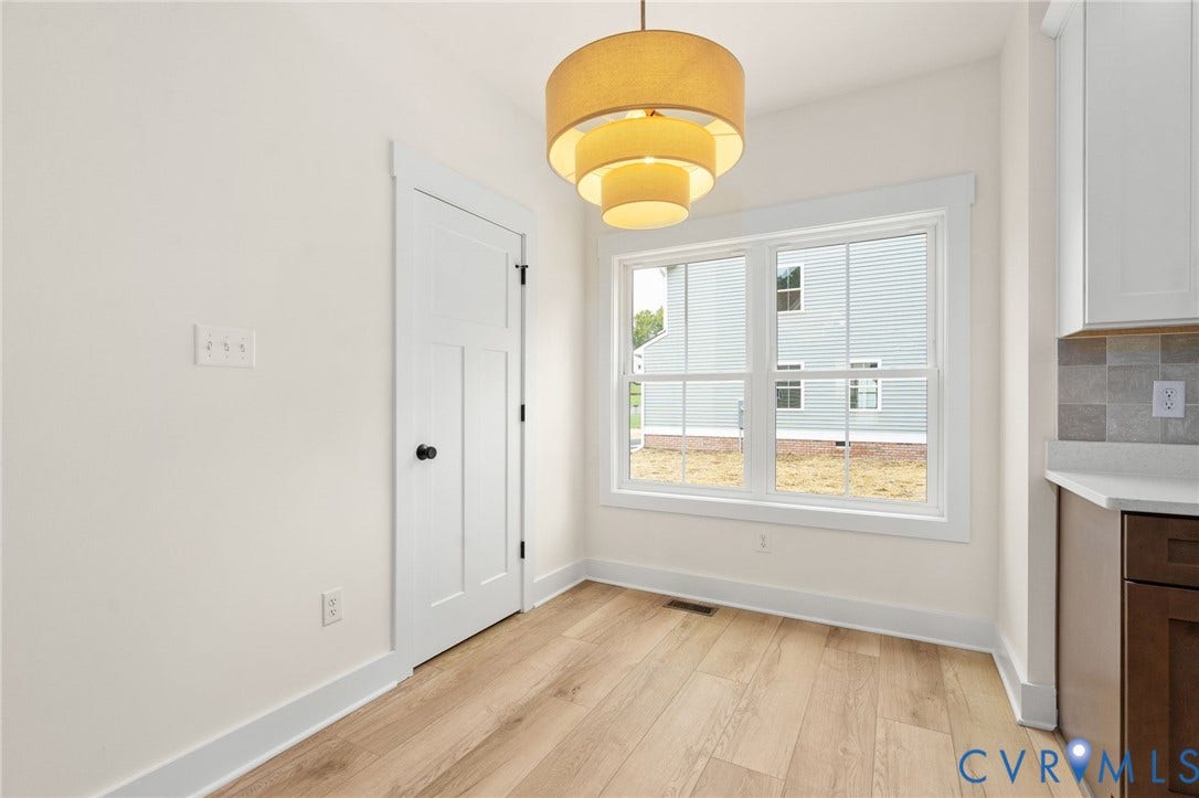 7603 Oster Drive, Chamberlayne Farms Area, Henrico, VA 23227 Wood-finish flooring, white trim details, modern tiered pendant light, built-in cabinetry, and tile backsplash