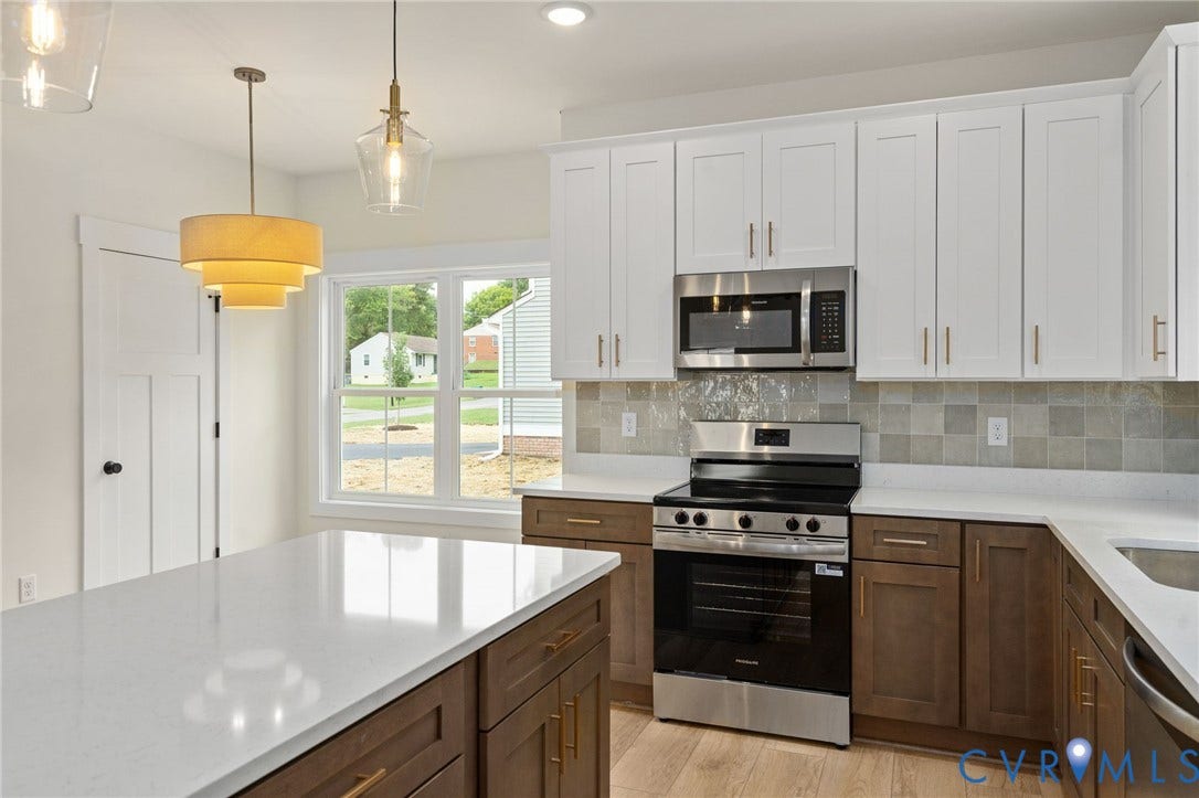 7603 Oster Drive, Chamberlayne Farms Area, Henrico, VA 23227 Kitchen featuring a central island with white countertop, two-tone cabinetry, stainless steel appliances, and a tiled backsplash