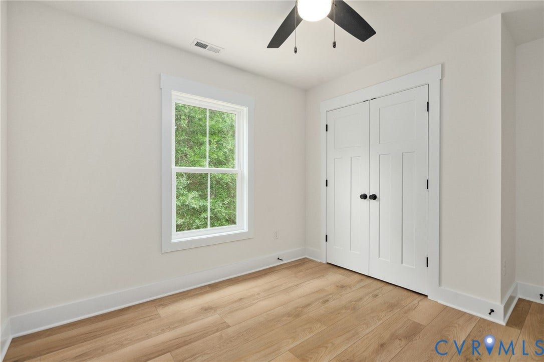 7603 Oster Drive, Chamberlayne Farms Area, Henrico, VA 23227 Wood-finish flooring, white walls, white trim, white paneled double doors with black hardware, and a ceiling fan with black blades