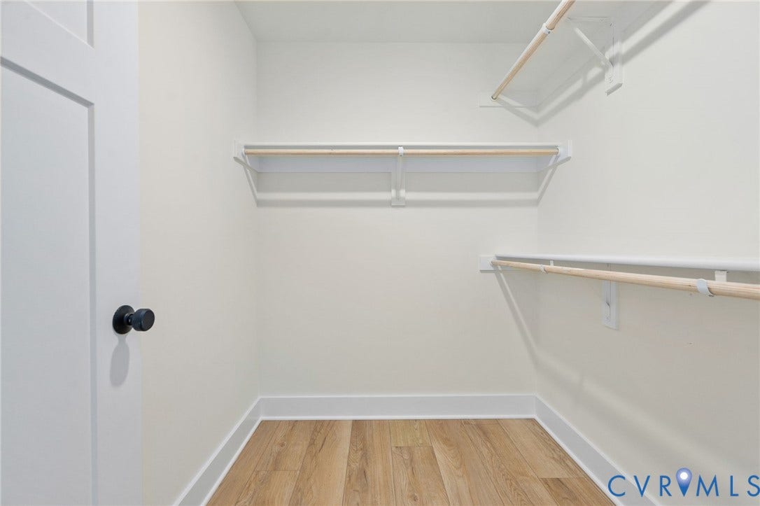 7603 Oster Drive, Chamberlayne Farms Area, Henrico, VA 23227 Walk-in closet featuring wood-finish flooring, white walls, and multiple hanging rods with shelving
