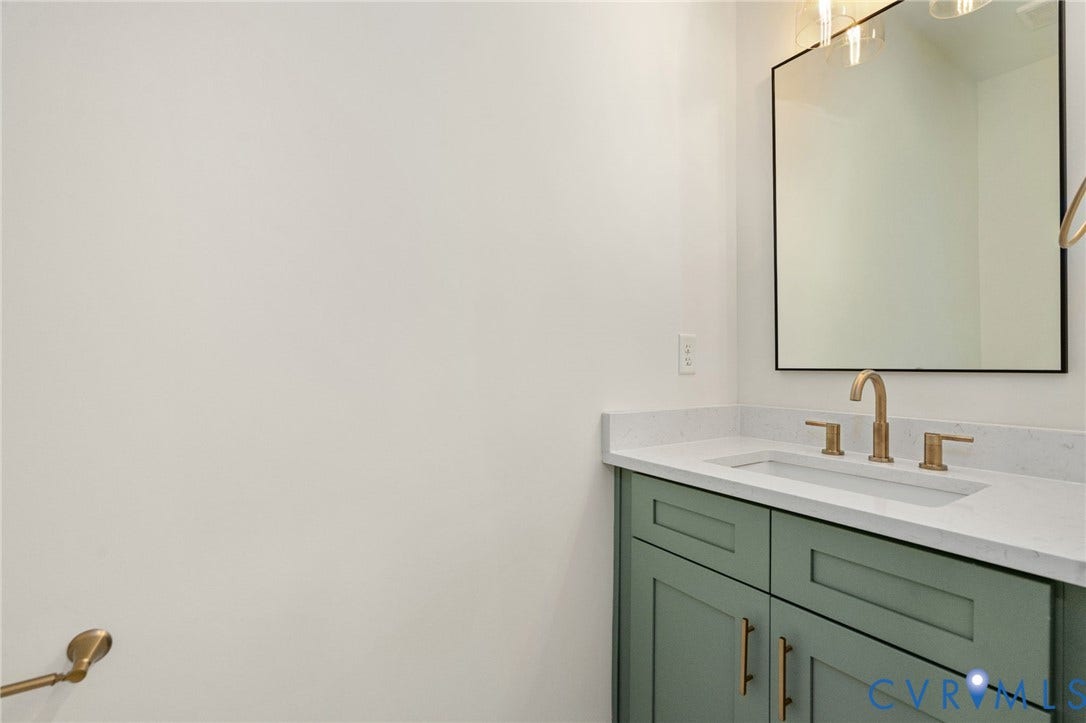 7603 Oster Drive, Chamberlayne Farms Area, Henrico, VA 23227 Mint green vanity with brass hardware, undermount sink, quartz countertop, and a sleek black-framed mirror