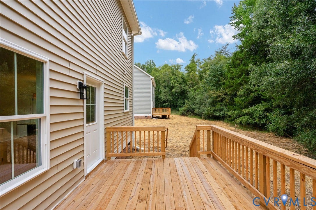7603 Oster Drive, Chamberlayne Farms Area, Henrico, VA 23227 Expansive wood deck with natural wood railings, tan siding exterior, white-framed windows, and a glass-paneled exterior door