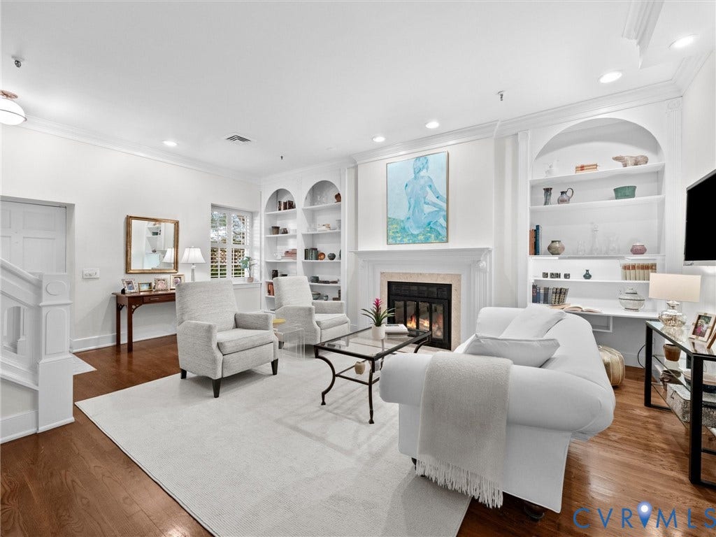 Hardwood flooring, recessed lighting, built-in shelving, a fireplace with a mantel, and crown molding