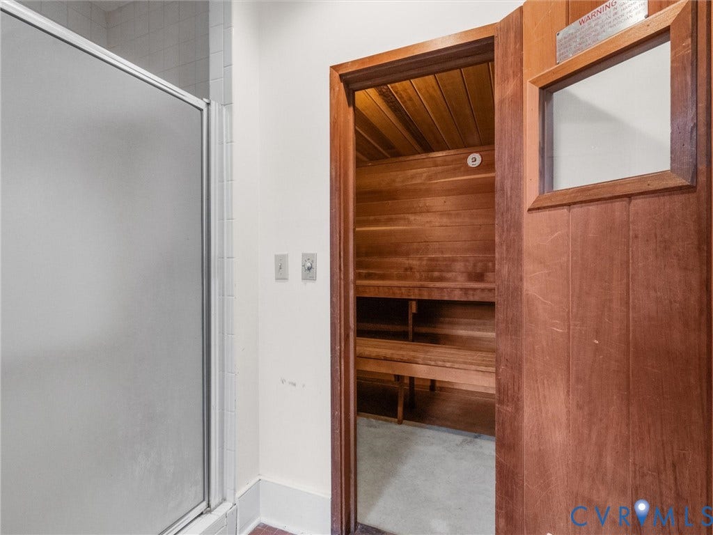 Frosted glass shower enclosure, wood-paneled sauna, and slatted wood benches