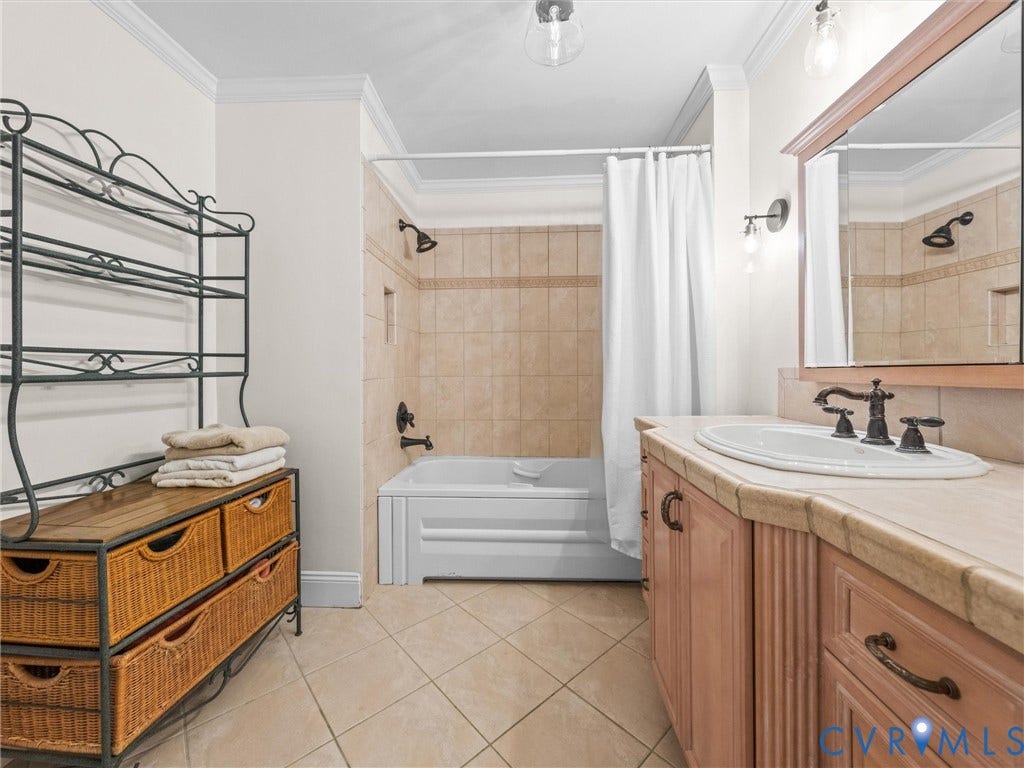 Tiled flooring with a bathtub-shower combination featuring subway-style tile surround