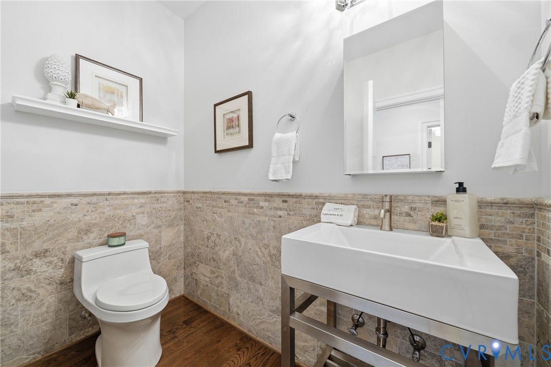 Well-appointed powder room with a white sink cabinet, tiled walls, and a clean, functional layout