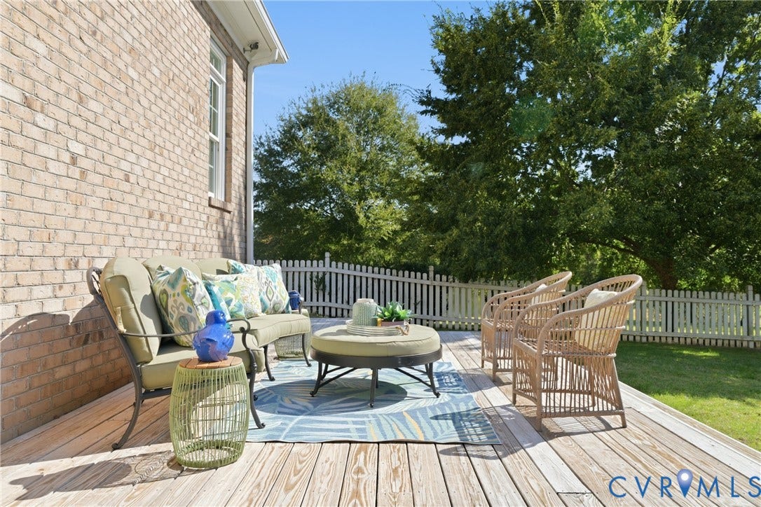 Rear wooden deck in the fenced portion of the yard is the perfect location for hosting gatherings or relaxing under the stars