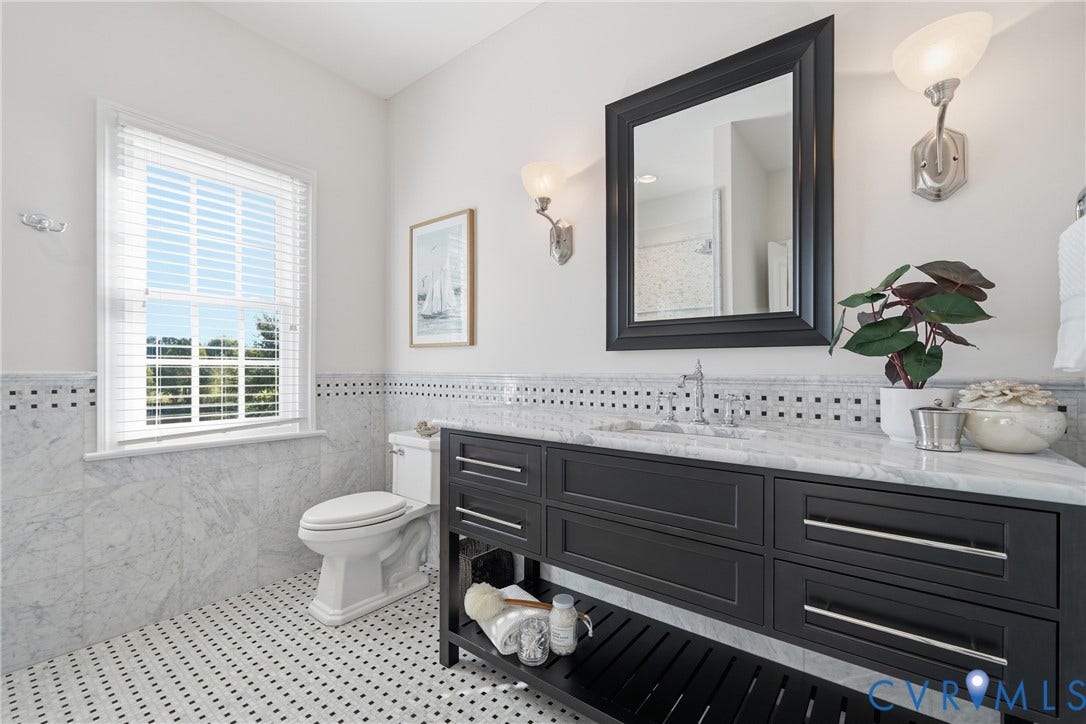 Ensuite bath with a dark wood vanity, ample storage, and frameless glass shower