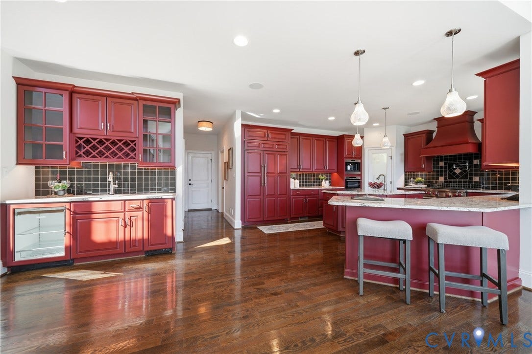 Custom kitchen featuring a wet bar with a built-in wine cooler, a convenient breakfast bar, walk-in pantry and butler's pantry