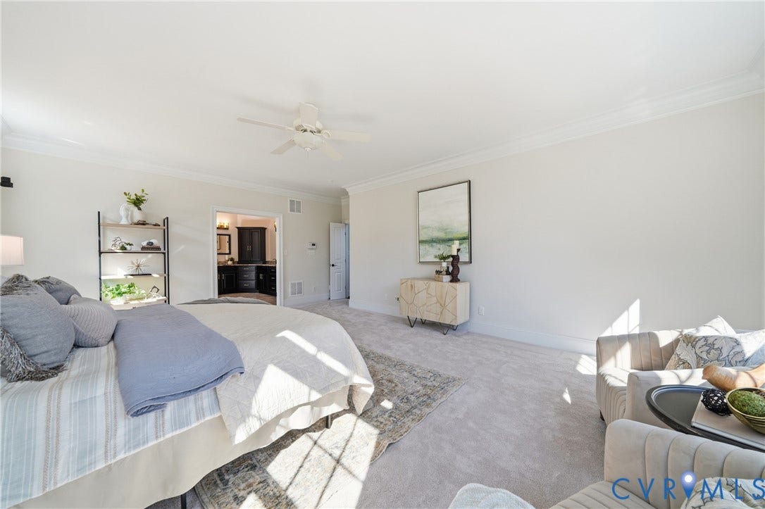 Primary bedroom with a spacious layout, new neutral carpeting (2026), and direct access to primary ensuite bathroom and closet