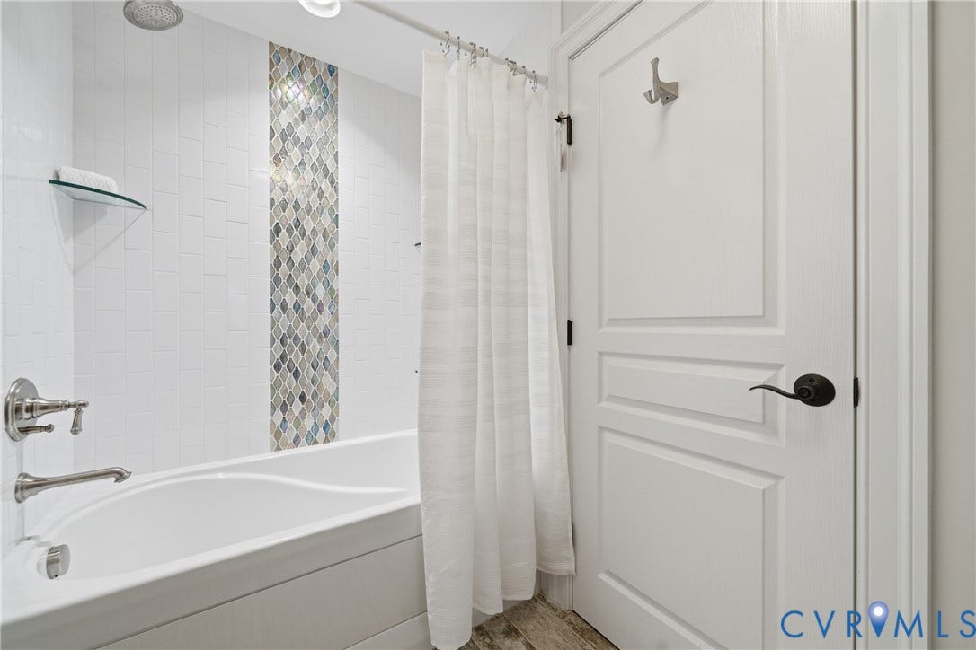 Full bathroom with decorative tile and shower/tub combo